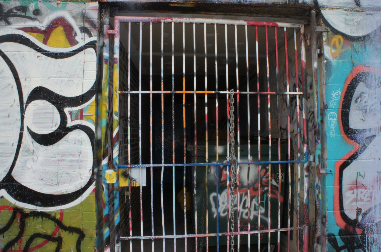 Graffiti-covered wall with a barred window