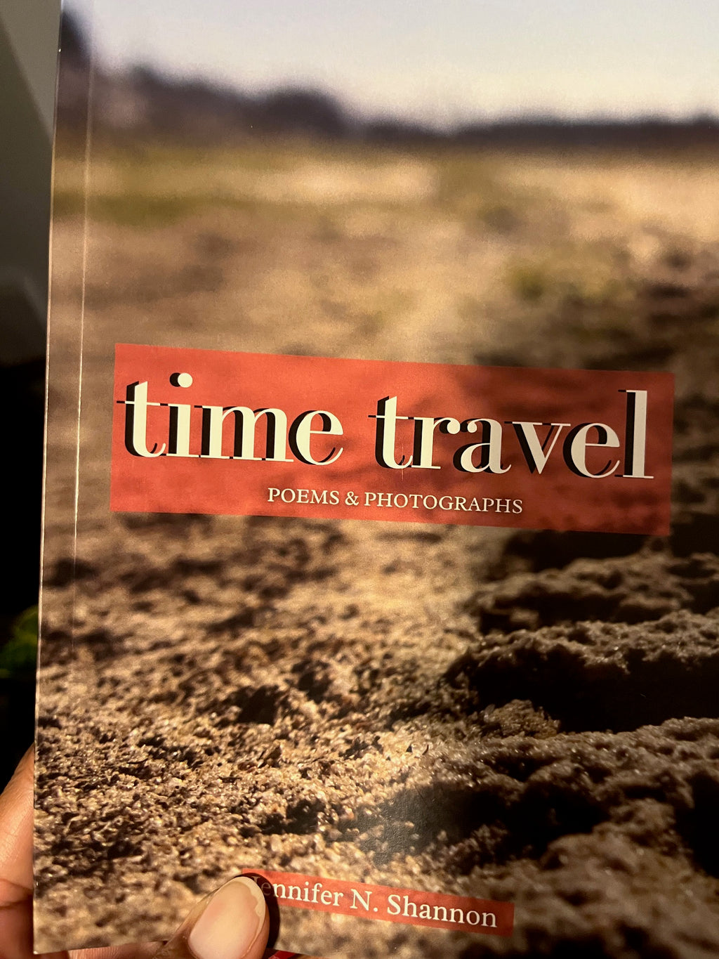 Book titled 'Time Travel' with a person holding it against a textured background